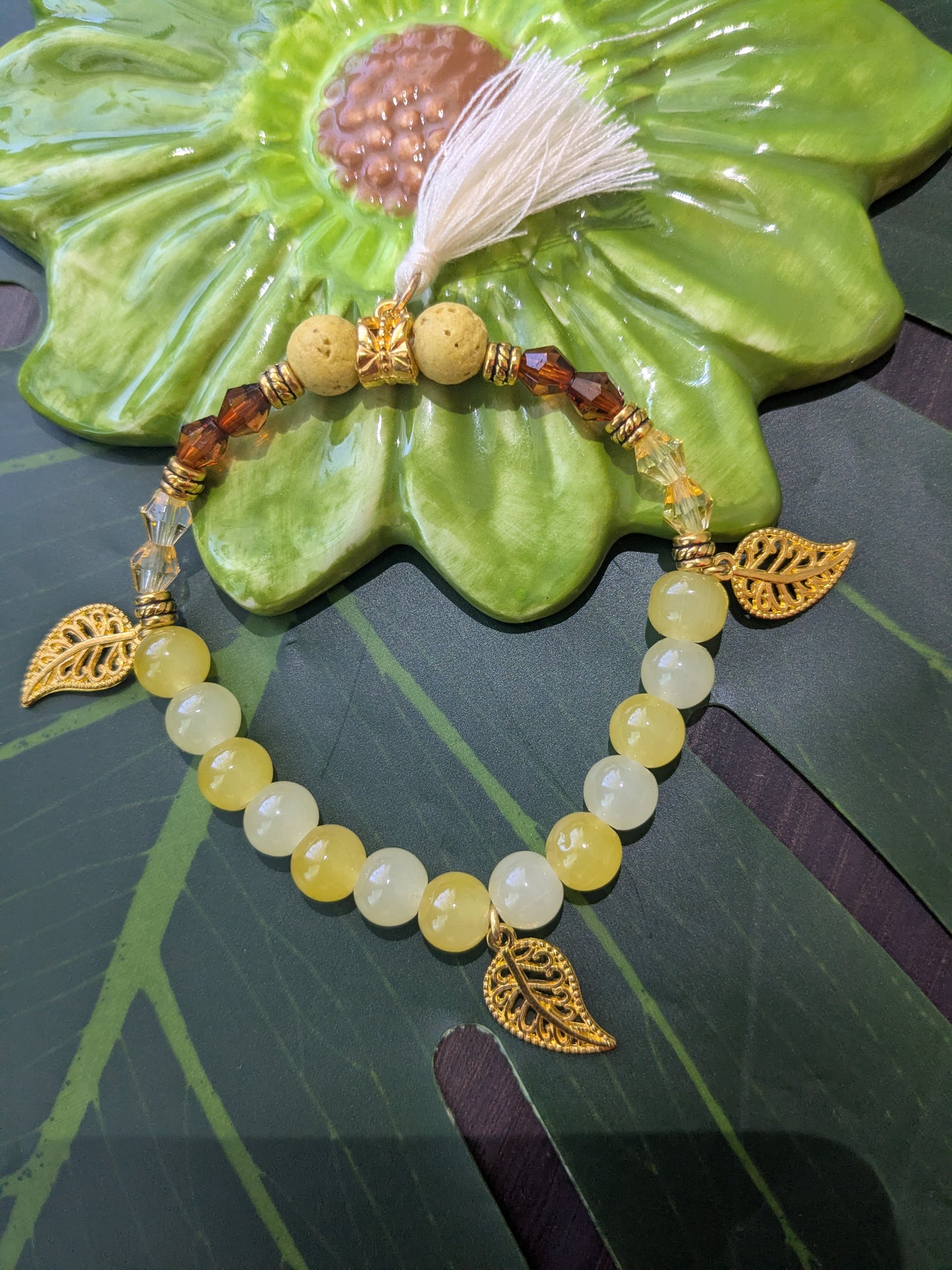 Beaded bracelet with lava rocks, charms and tassel