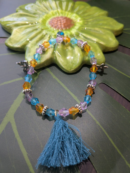 Beaded bracelet with tassel and charms